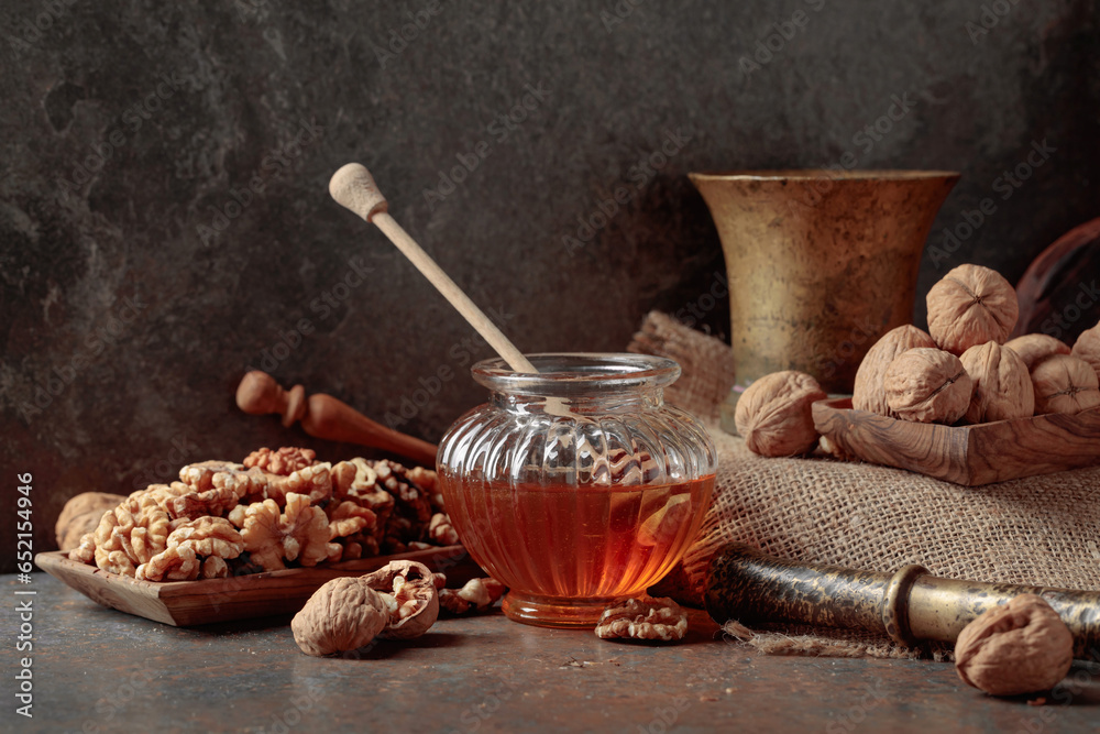 Fototapeta premium Honey and walnuts on a kitchen table.
