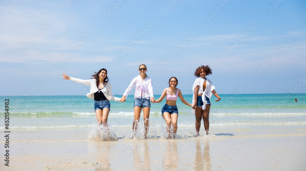 Group of happy and fun teenager girls jumping on beach. Four teenager girl female enjoying on tropical beach. Vacation trip summer holiday.