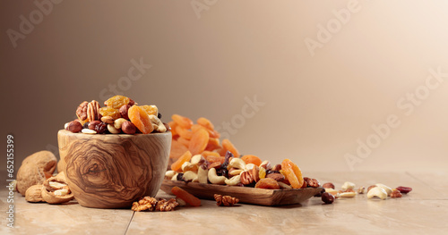 Dried fruits and nuts on a beige ceramic table.