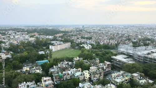 4K Aerial Shots of New Delhi Residential Suburbs on a beautiful day gliding over Rooftops, streets, parks and markets in India photo