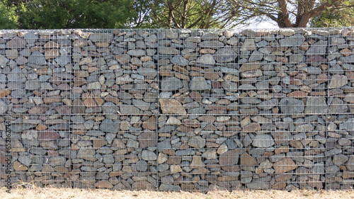 stone textured fence gabion steel metal grated stone wall basket made of mesh and stones background wall horizontal facade photo