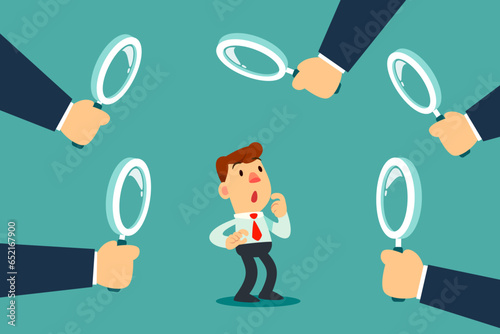 businessman surrounded by big hands with magnifying glass