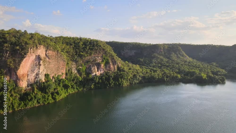 Breathtaking aerial shot of Teyu Cuare Park in San Ignacio, Misiones, Argentina. A rugged rock wall amidst lush jungle, with a serene river for a remarkable natural landscape. Breathtaking aerial shot of Teyu Cuare Park in San Ignacio, Misiones, Argentina. A rugged rock wall amidst lush jungle, with a serene river for a remarkable natural landscape.