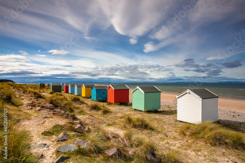 Stampa su tela Colorful wooden beach huts at Findhorn beach, Moray coast, Scotl