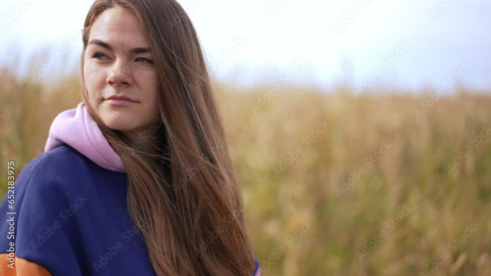 Side view portrait of young woman scrolling social media app in smartphone looking around. Caucasian charming confident lady in autumn field outdoors Side view portrait of young woman scrolling social media app in smartphone looking around. Caucasian charming confident lady in autumn field outdoors