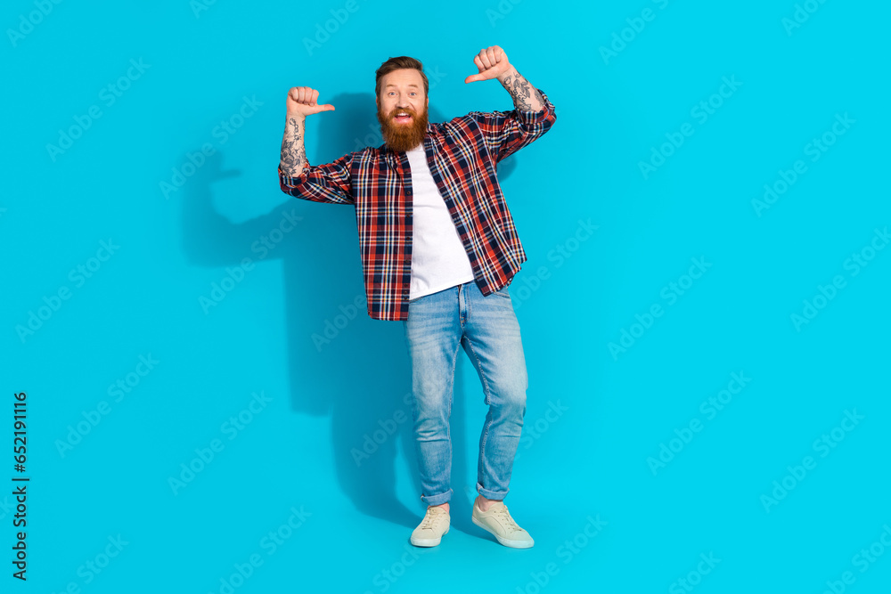 Full size photo of funny funky optimistic man wear plaid shirt denim pants indicating at himself isolated on blue color background Full size photo of funny funky optimistic man wear plaid shirt denim pants indicating at himself isolated on blue color background