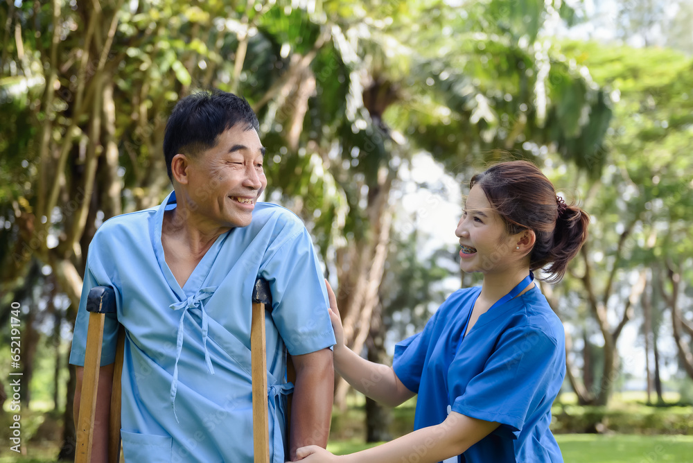 Asian Young Female Doctor Help Support Senior Patient and Provide Encouragement During Treatment. Rehabilitation or Physical Therapy of Asian Retired Patients with Crutches Wooden. Asian Young Female Doctor Help Support Senior Patient and Provide Encouragement During Treatment. Rehabilitation or Physical Therapy of Asian Retired Patients with Crutches Wooden.