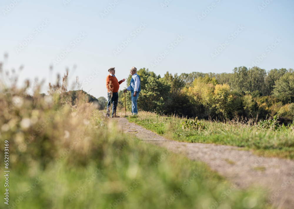 Two old friends standing in the fields, talking about old times Two old friends standing in the fields, talking about old times
