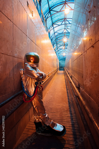 Spaceman in the city at night standing in narrow passageway photo