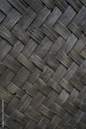 the texture of the woven old bamboo wall with a worn brown color that is worn with age
