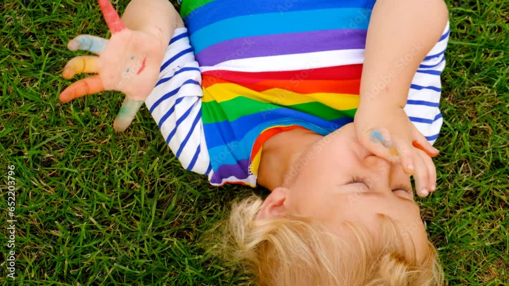 Hands paint a smile in a child arms. Selective focus. Hands paint a smile in a child arms. Selective focus.