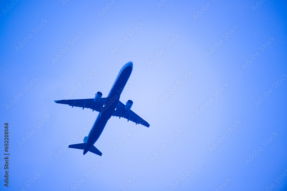 A jetliner flies in the blue sky. City silhouette landscape at dusk, Taipei city.