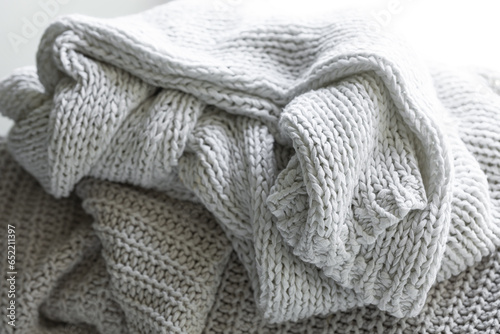 Knitted warm grey sweater or scarf, cozy composition in the home atmosphere.