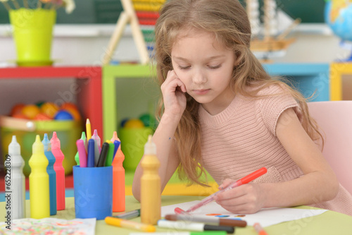 Portrait of cute girl drawing picture at home