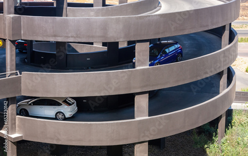 cars driving down on a mall multilevel parking lot , concrete structure parking built on pillars
