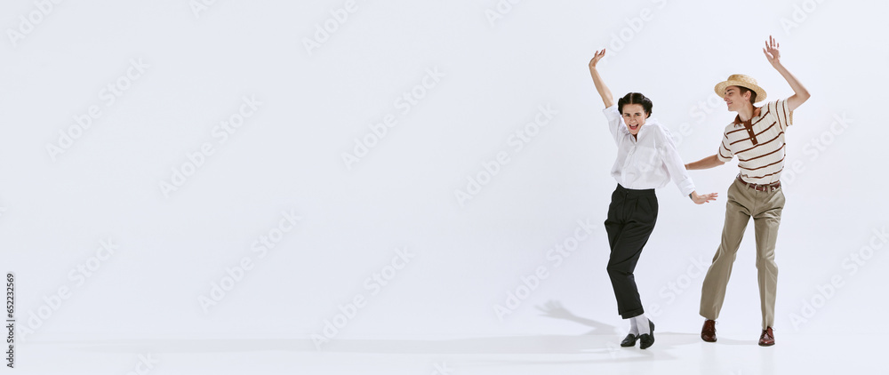 Pretty, emotional young people, beautiful woman and handsome man dancing isolated on white studio background. Concept of art, hobby, retro dance style, choreography, beauty. Ad. Banner