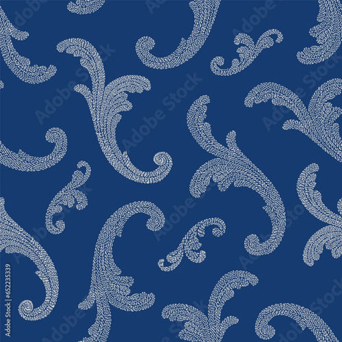 Vector seamless pattern of silver embroidered floral swirls on a dark indigo blue background