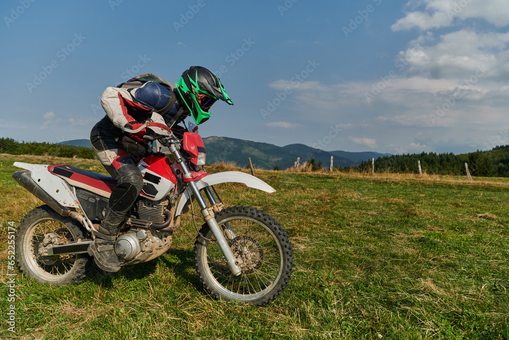 A motorcyclist equipped with professional gear, rides motocross on perilous meadows, training for an upcoming competition. A motorcyclist equipped with professional gear, rides motocross on perilous meadows, training for an upcoming competition.
