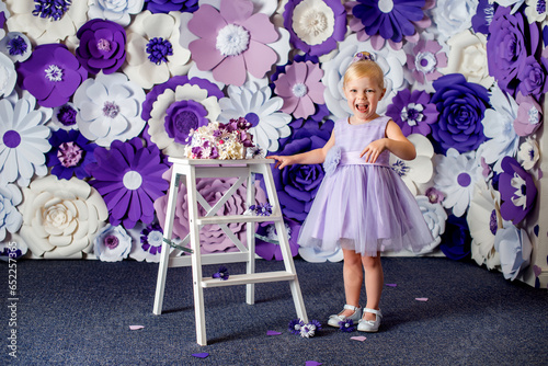A girl in a light purple dress with a festive cake on a floral white-purple background. Birthday photoshoot. © Alena Vilgelm