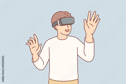 Boy wearing VR glasses enthusiastically uses new technology to immerse himself in virtual reality