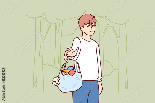 Man throws out bag of garbage in wrong place, polluting nature and showing lack of consciousness. Bad guy polluting ecology with plastic waste and littering with unrecyclable rubbish forest or park