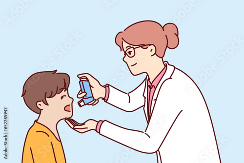 Woman doctor with inhaler helps boy cope with asthma attack or get rid of bronchial health problems. Caring pediatrician giving inhaler to child, recommending use of medicated spray to fight flu photo
