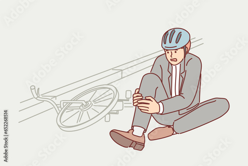Man fell from bicycle and broke leg while commuting, and is sitting on ground waiting for doctor