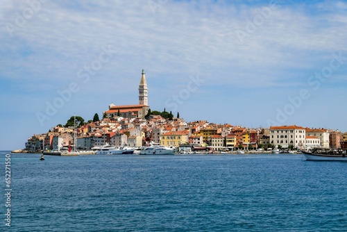 View of Rovinj fishing port with colorful architecture and small ships floating on water, Croatia © Christian Schmidt/Wirestock Creators