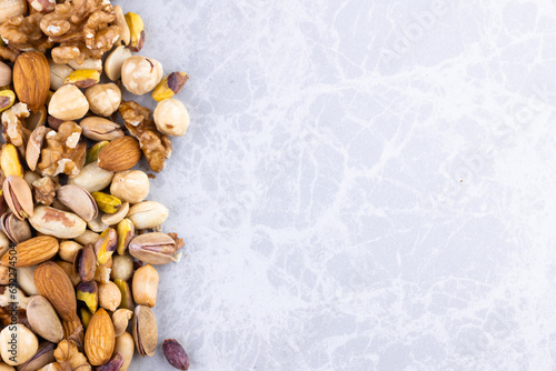 mixed nuts background. almonds, pistachios, hazelnuts, walnuts, hazelnuts, on the edge of white marble.