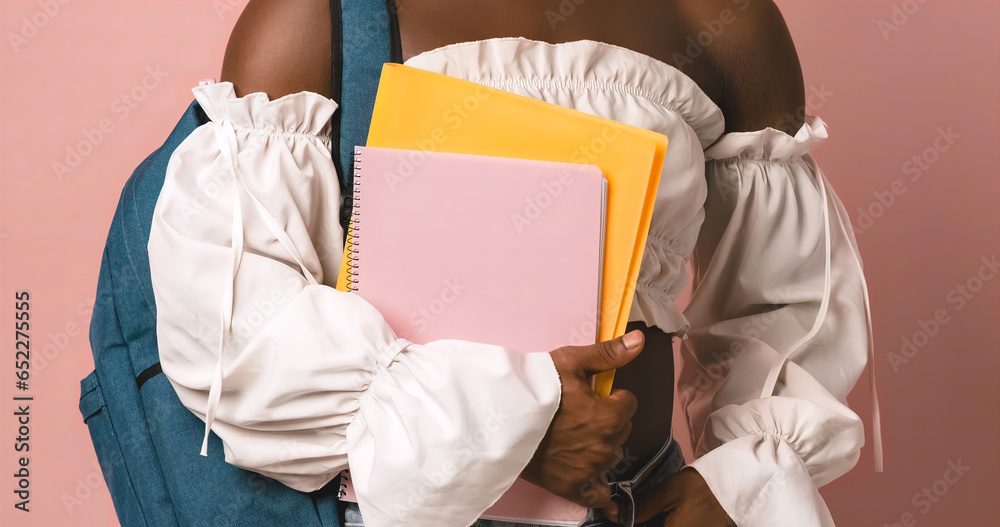 Crop black transgender student holding folder and notebook