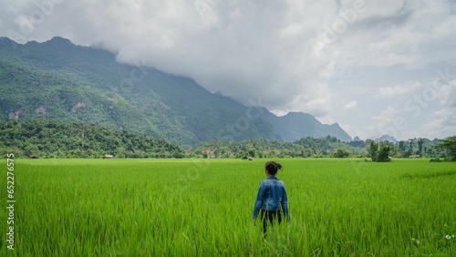 Beautiful view of a female enjoying the view in the rice field in Lao © Kitsana_navin/Wirestock Creators