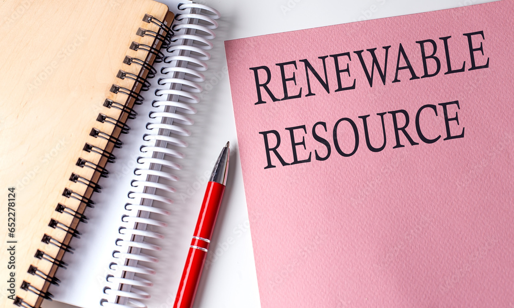 RENEWABLE RESOURCE word on the pink paper with office tools on white background RENEWABLE RESOURCE word on the pink paper with office tools on white background