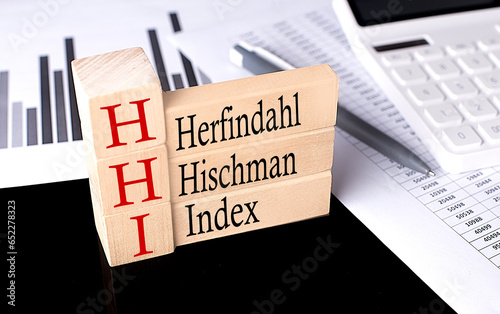 Word HHI - Herfindahl Hirschman Index made with wood building blocks, business concept photo