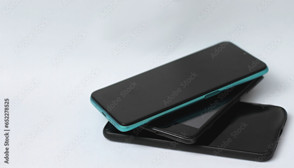old mobile phones piled up on a table with white background no people stock photo old mobile phones piled up on a table with white background no people stock photo
