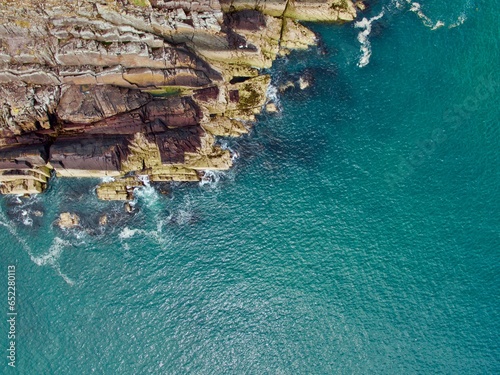 Aerial view of green cliffs facing the sea in the morning