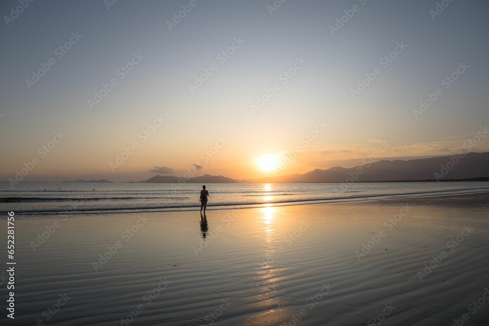 Person's silhouette on Indaia Beach at sunset. Bertioga, Sao Paulo.