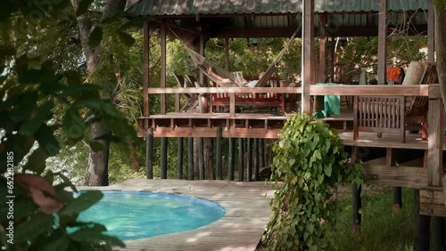 Man in hammock relaxing at poolside chalet at Zambezi river in Zimbabwe photo