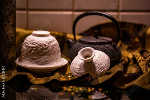 an old iron teapot sitting next to a couple of cups photo