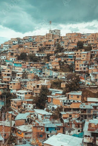 Vertical drone shot of a rural houses in a city under the cloudy sky © Alexander Giraldo/Wirestock Creators