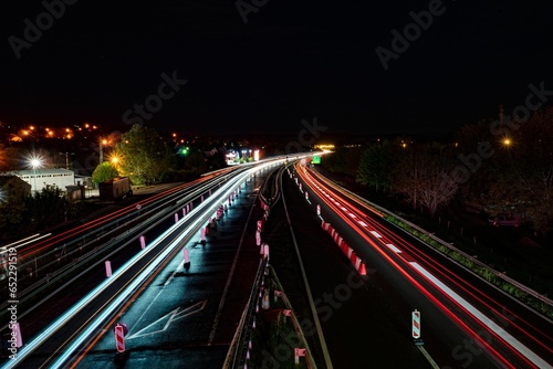 Busy urban highway at night illuminated by the colorful lights of the traffic signals