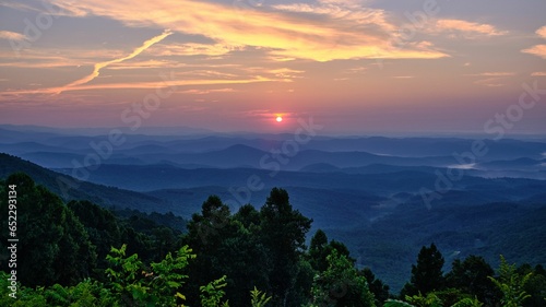 Landscape of mountains surrounded by greenery under the sunlight during the sunset