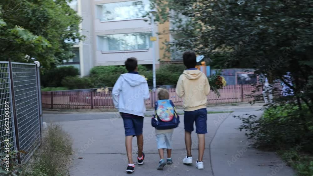 First day at school for a firstgraden, child starting school, bringing flowers for the teacher, family members going with him