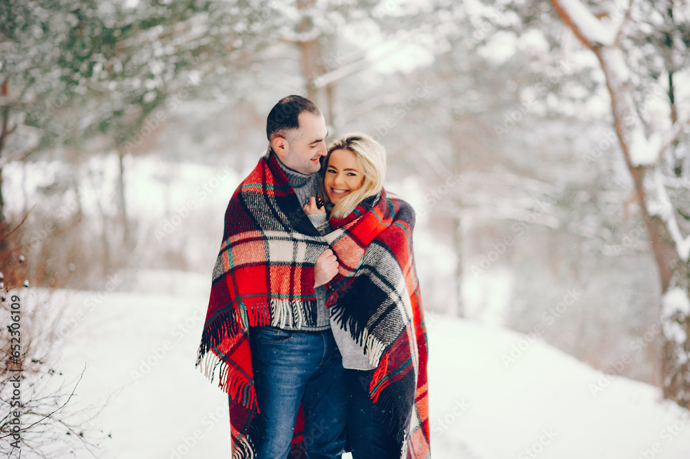 Beutiful woman in a winter park with her husband