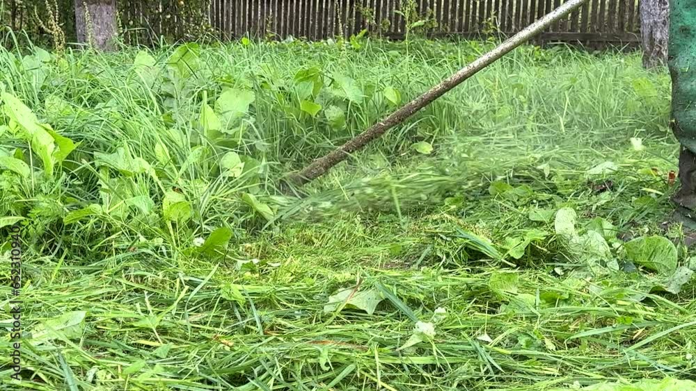 Gardener mows weeds grass. Man cutting grass in yard by using string trimmer. Worker lawn mower cutting garden. Lawn mowing machine. Grass Trimmer and Grass Cutter. lawn maintenance service. Gardener mows weeds grass. Man cutting grass in yard by using string trimmer. Worker lawn mower cutting garden. Lawn mowing machine. Grass Trimmer and Grass Cutter. lawn maintenance service.