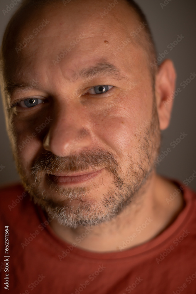 Close-up portrait of a casually unshaved man in his 40s, displaying a friendly expression and an everyday appearance Close-up portrait of a casually unshaved man in his 40s, displaying a friendly expression and an everyday appearance
