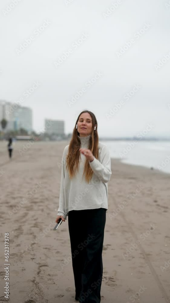 portrait beautiful caucasian woman walking relaxed on the beach listening to music portrait beautiful caucasian woman walking relaxed on the beach listening to music