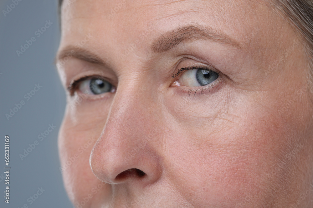 Fototapeta premium Senior woman with aging skin on grey background, closeup. Rejuvenation treatment