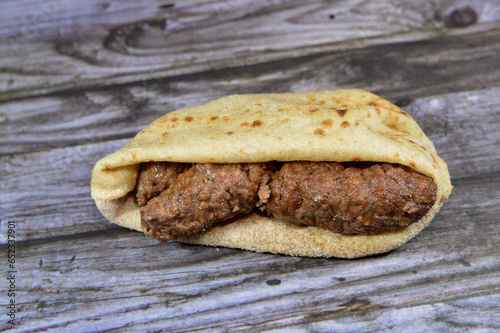 Arabic cuisine traditional food beef Kofta, kebab and tarb kofta shish, minced meat wrapped in lamb fat charcoal grilled and served in flatbread sandwich, oriental grilled barbecued meat food photo