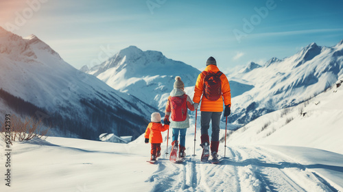Happy family in winter clothing at the ski resort, winter time, watching at mountains photo
