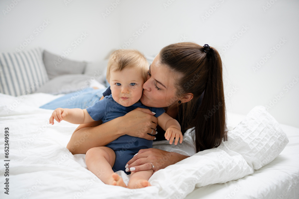 young, beautiful mother is cuddling with her cute baby